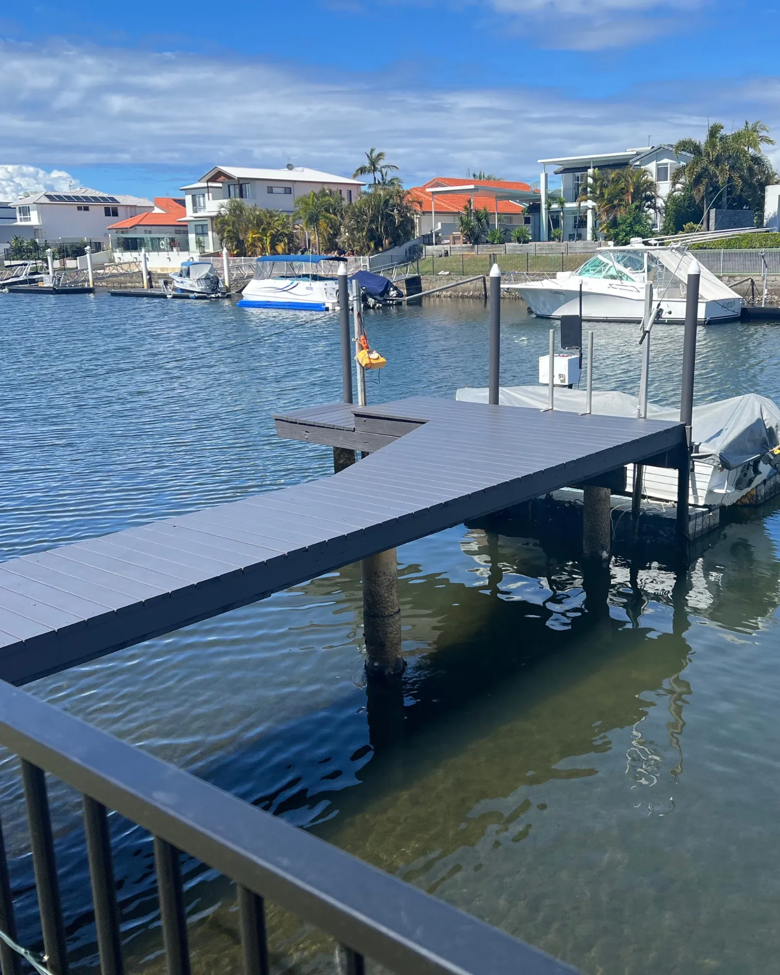 Custom T-shaped pontoon with charcoal composite decking on a Gold Coast canal