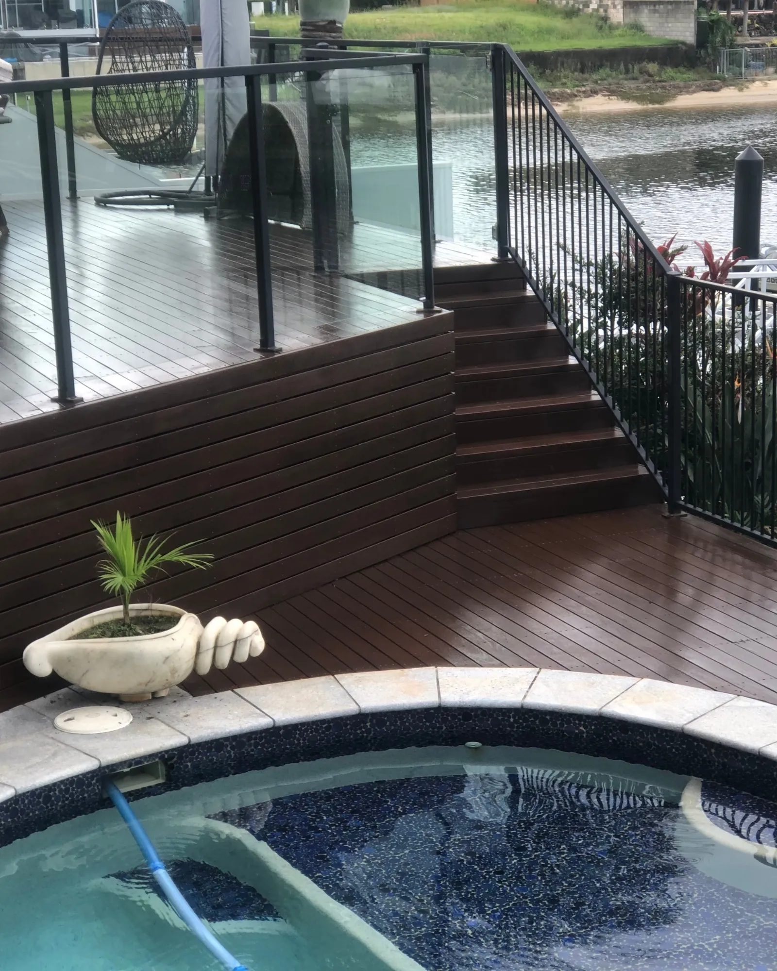 Wraparound hardwood pool deck with glass balustrade and integrated spa on the Gold Coast